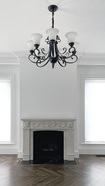 An image of a room with a large window covered by a white roller blind.