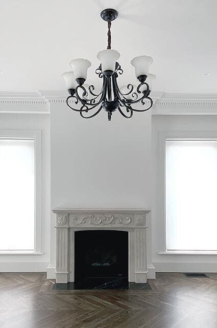 An image of a room with a large window covered by a white roller blind.