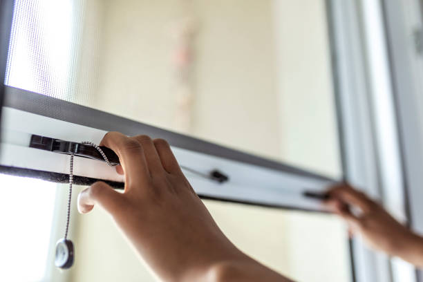 Woman hand hold retractable pleated insect screen holder to open or close the window, mosquito nets